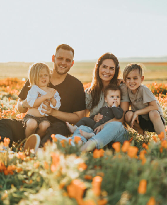 Happy healthy family sitting in field in Oxnard, CA